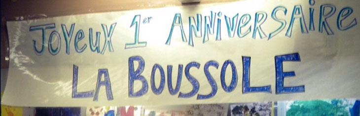 Handmade sign reading "Joyeux premier anniversaire La Boussole"